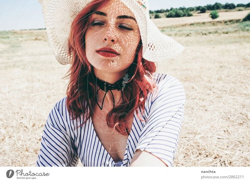 Redhead model protecting herself from sun with a hat in summer Lifestyle Elegant Skin Face Cosmetics Relaxation Vacation & Travel Summer Sun Sunbathing
