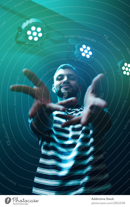Man dancing in spotlight outstretching hand forward Dance Hand zumba Energy Stage lighting Performance rhythmic Palm of the hand Modern Forward Style Light