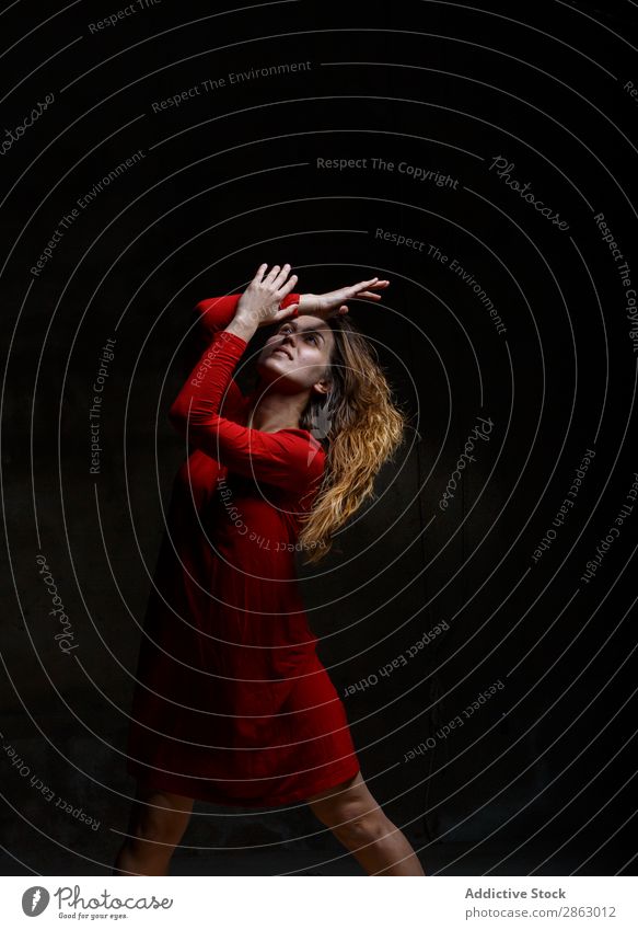 Young woman dancing in darkness Ballet Dance Ballerina red dress Dress Woman Hand Performance Room Red Elegant Dark Art pose Shows Smock obscurity grace