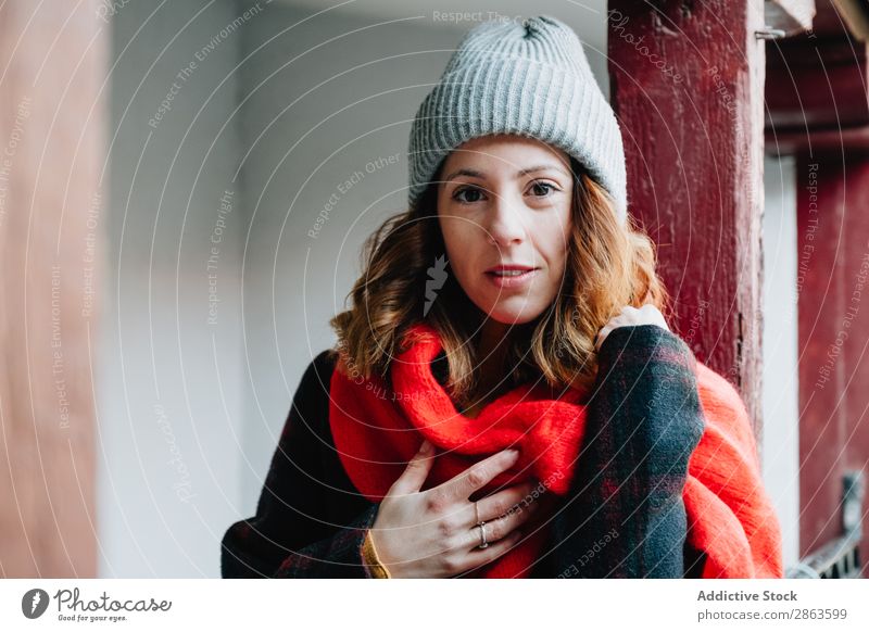 Positive woman in warm wear near house Woman Friendliness House (Residential Structure) Warmth Hand Chest Wear Winter Youth (Young adults) Building Lady