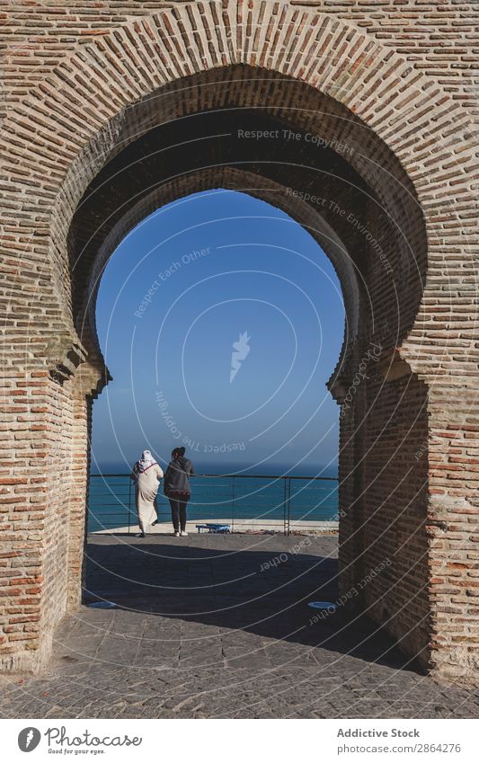 Arch of building and women looking at seascape Building Woman seaside Fence tangier Morocco Sky Ocean Construction Wonderful Architecture Looking Resting