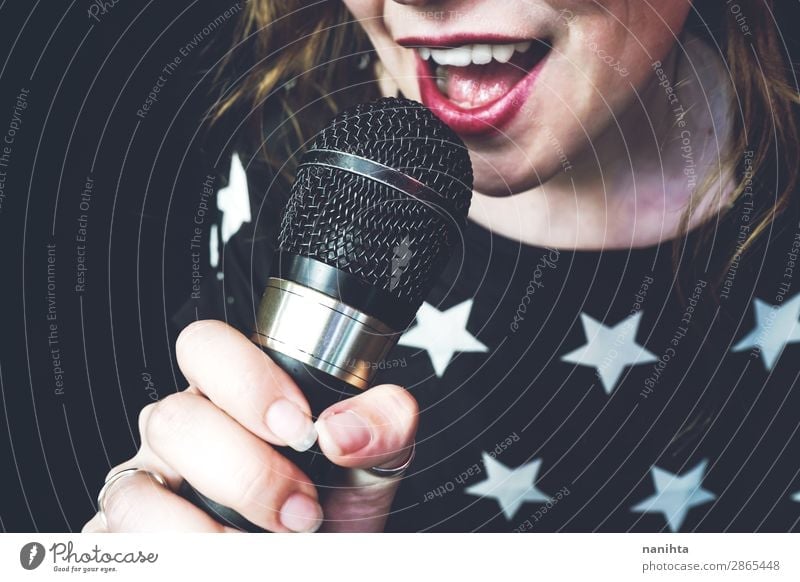 Young woman singing a song with a microphone Lifestyle Style Joy Face Leisure and hobbies Technology Entertainment electronics Human being Feminine