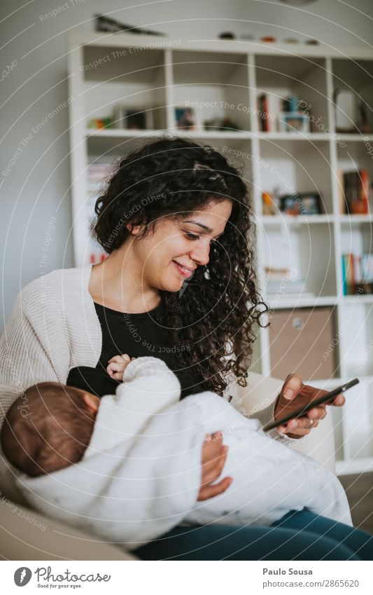 Mother breastfeed baby while playing with smartphone Lifestyle Cellphone Human being Child Baby Toddler Young woman Youth (Young adults) Adults 2 0 - 12 months