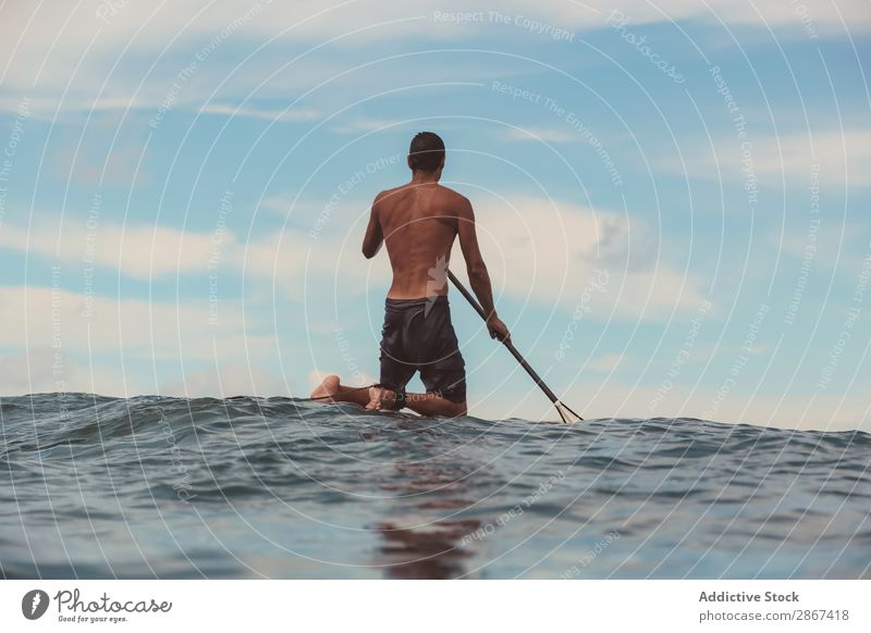Man with paddle on surf board waving on water Surfboard Water Surface Sports Bali Indonesia Paddle Sky Ocean Heaven Blue Paddling Ripple Landscape