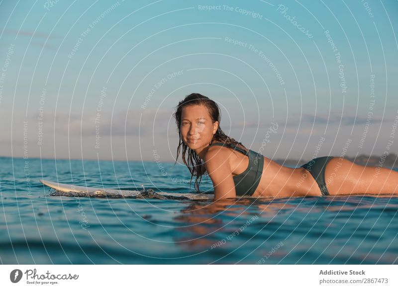 Smiling woman on surf board floating on water Woman Surfboard Water Sports Bali Indonesia Surfing Wave Floating Blue Ocean Surface Heaven Cheerful Balance