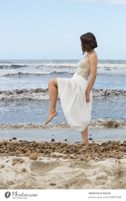 Charming young woman on shore near water Woman Water Coast Ocean Beach Lady waving Posture Youth (Young adults) Thin Attractive Vacation & Travel Passion