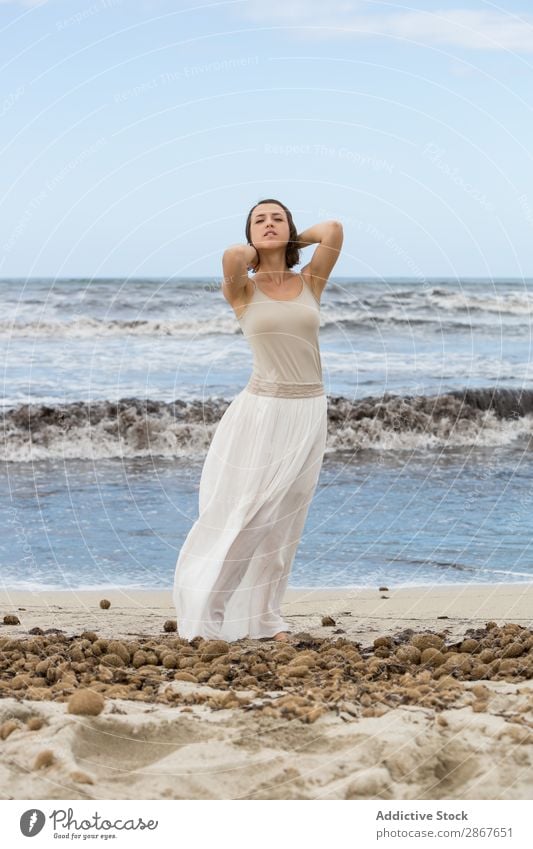 Charming young woman on shore near water Woman Water Coast Ocean Beach Lady waving Posture Youth (Young adults) Thin Attractive Vacation & Travel Passion