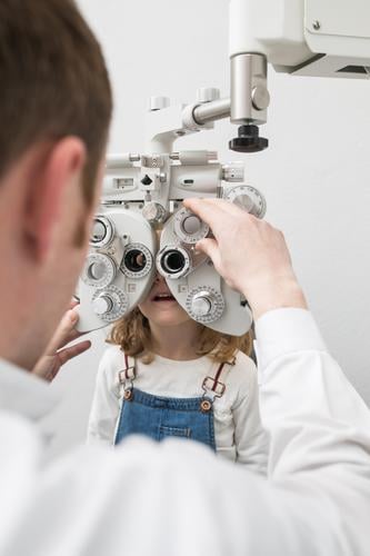 Optician testing a girl's eyes clinic device diagnose Display Doctor Examinations and Tests Eyes Person wearing glasses Healthy Hospital hygienics Child