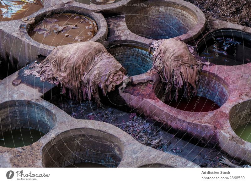 Heaps of dirty textile near containers with colorant liquid Container Dirty Liquid Colorant Marrakesh Morocco Stone Dye Accumulation duster Grunge Wash