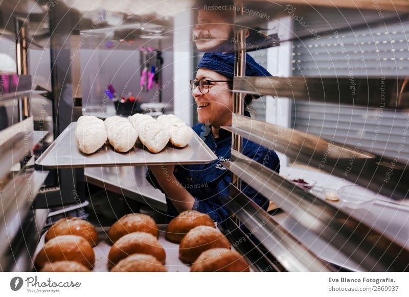 woman holding rack of rolls in a bakery. Bread Happy Kitchen Restaurant School Work and employment Profession Camera Feminine Woman Adults 1 Human being