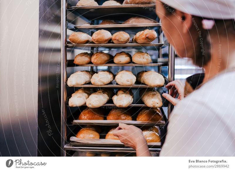 woman holding rack of rolls in a bakery. Bread Happy Kitchen Restaurant School Work and employment Profession Camera Feminine Woman Adults Hand Building