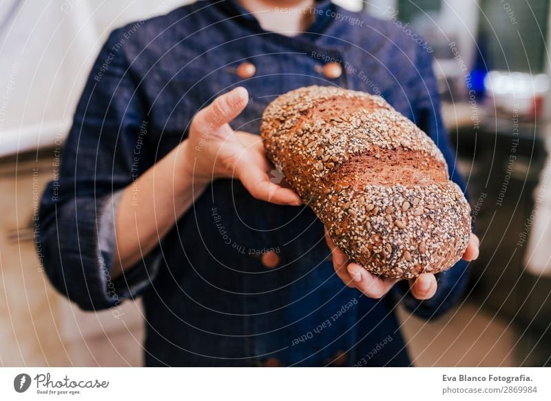 chef in bakery holding seed bread. daytime Bread Nutrition Shopping Healthy Work and employment Profession Business Human being Feminine Woman Adults Hand 1