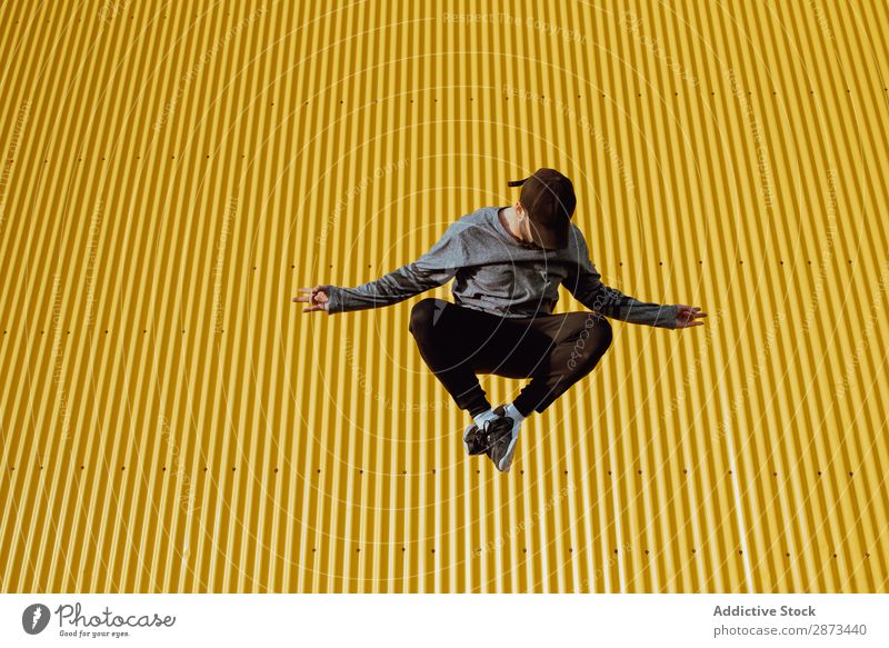 Man jumping near yellow wall Street Jump Wall (building) Yellow Building Stunt Style Easygoing Hip & trendy Fitness Action City Lifestyle Leisure and hobbies