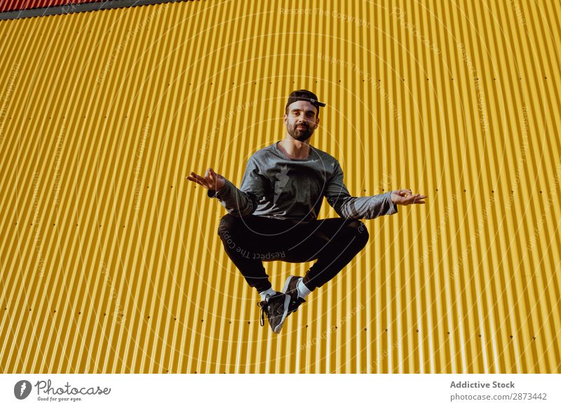 Man jumping near yellow wall Street Jump Wall (building) Yellow Building Stunt Style Easygoing Hip & trendy Fitness Action City Lifestyle Leisure and hobbies