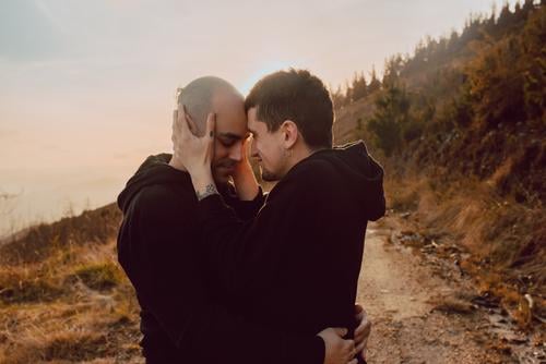 Men hugging and kissing in forest Homosexual Couple Park Kissing Love holding hands Forest Lanes & trails Beautiful weather Closed eyes Sun Nature Man romantic