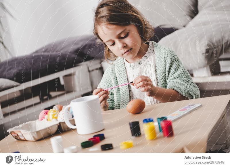 Girl coloring chicken egg at table Easter Egg Colouring Painting and drawing (object) Brush Child Table Spring Chicken Vacation & Travel Decoration
