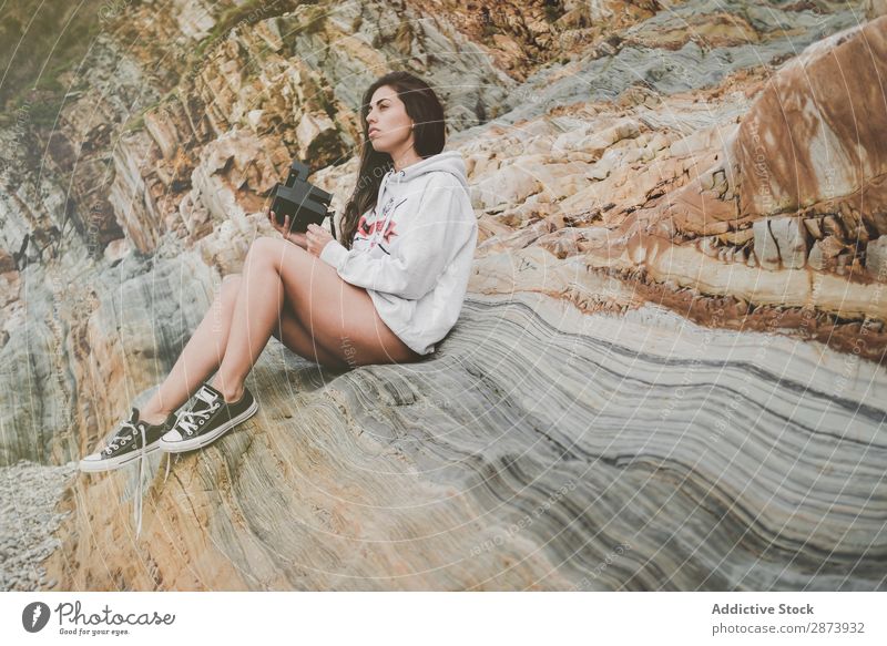 Lady with camera on shore near stones and water Woman Coast Ocean Camera Water Cheerful Retro Youth (Young adults) Lifestyle Stone Walking Underwear Sweater