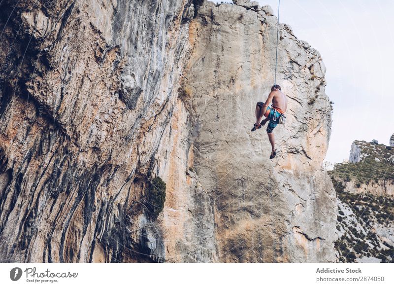 Anonymous climber handing on cliff Climber Cliff Hanging Rope Extreme Sky Blue Mountain Rock Sports challenge Action Success Power Height Adventure Risk belay
