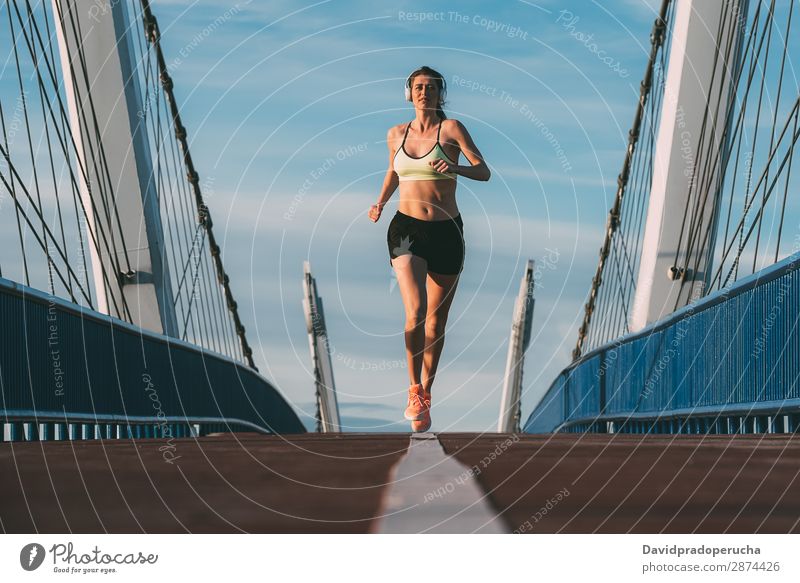 Young fit blonde woman running on the bridge Woman Running Practice Fitness work out Lifestyle Movement Action Jogging Bridge Horizontal Athletic Healthy