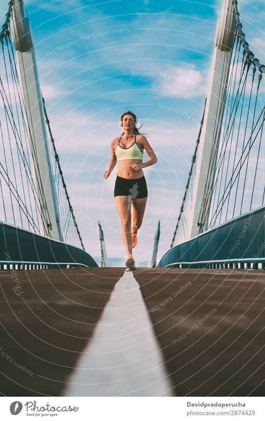 Young fit blonde woman running on the bridge Woman Running Practice Fitness work out Lifestyle Movement Action Jogging Bridge Vertical Athletic Healthy