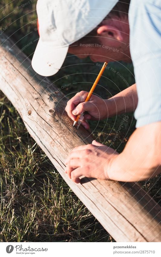 Man making mark while working in garden Summer Garden Work and employment Craft (trade) Tool Human being Adults Grass Building Hat Wood White Precision