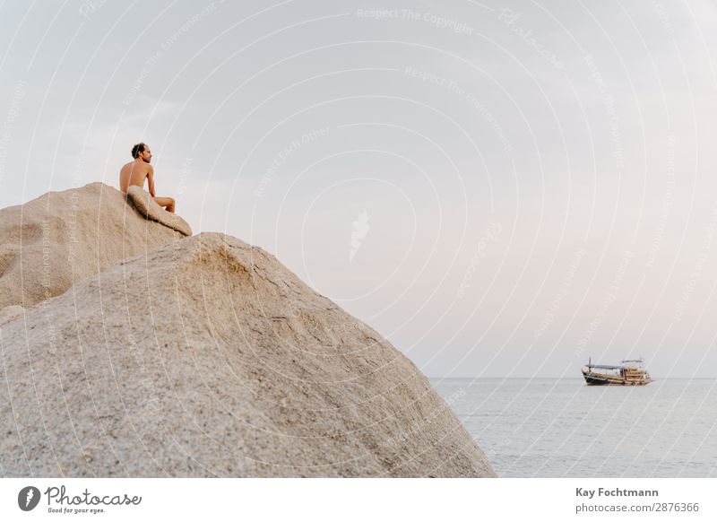 Man with free upper body sits on big rock by the sea Happy Healthy Fitness Wellness Life Harmonious Well-being Relaxation Calm Meditation Vacation & Travel