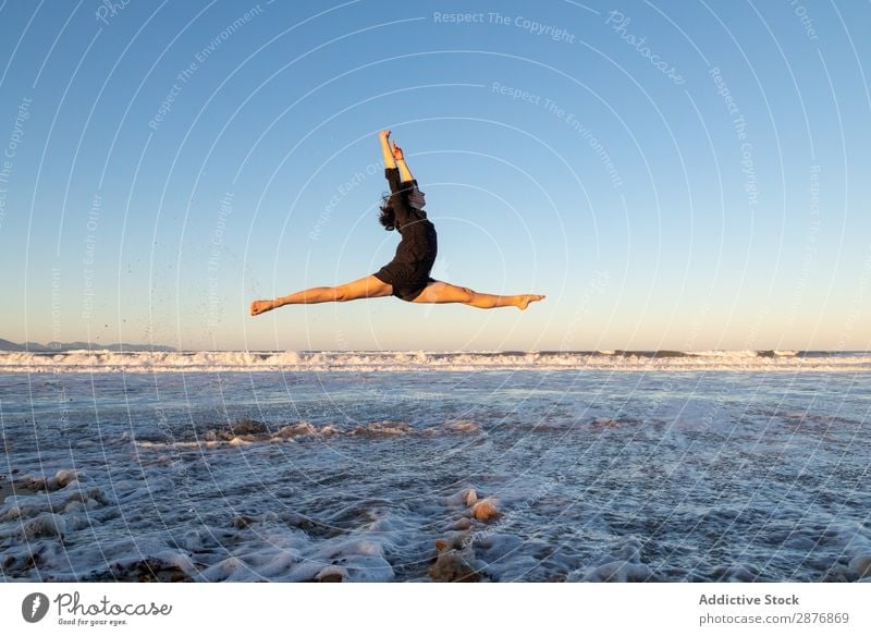 Woman jumping near water on shore Dancer Coast Water Jump Ocean Legs Side Air Sky waving Sand Blue Youth (Young adults) Ballet Lifestyle Beach
