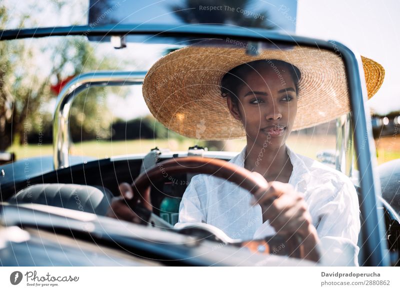 Black woman driving a vintage convertible car Woman Car Driving Ethnic Happy Convertible Street Luxury Looking away Front view Smiling Classic 60's Beautiful