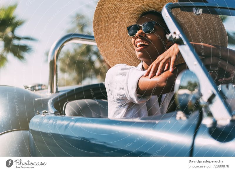 Black woman driving a vintage convertible car Woman Car Driving right steering wheel Ethnic Convertible Happy Street united kingdom Front view Vintage Luxury