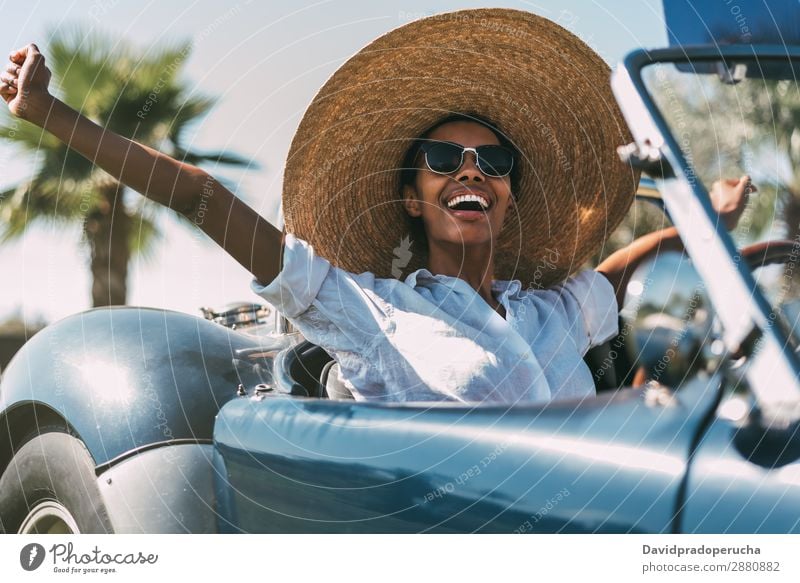 Black woman driving a vintage convertible car Woman Car Driving right steering wheel Ethnic Convertible Street united kingdom Front view Vintage Luxury