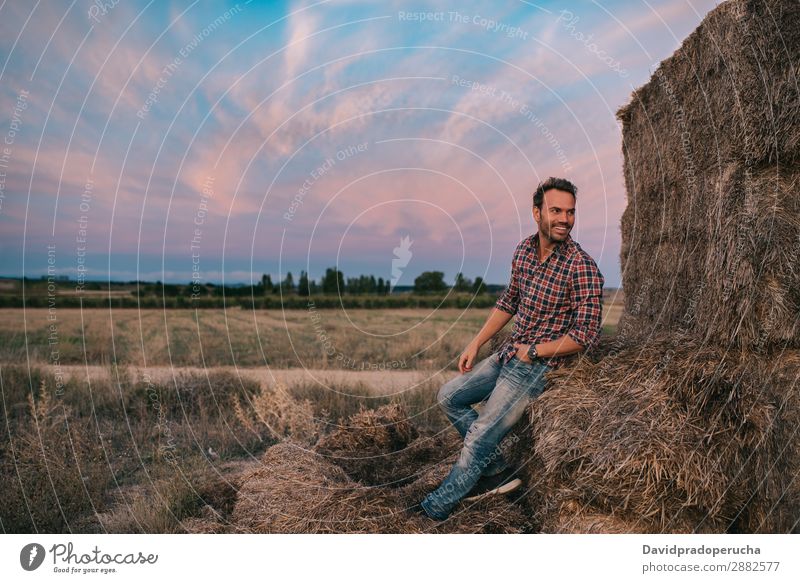 Happy man sitting on a pile of hay Man Farmer Hay Summer Caucasian Landscape Nature Countries Sky Relaxation Lifestyle Work and employment Seasons Exterior shot