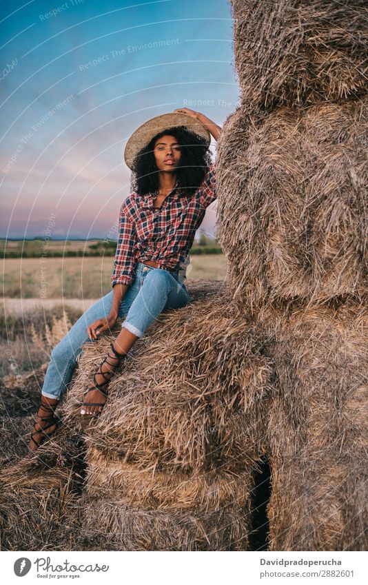 Happy black young woman sitting on a pile of hay Woman Farmer Hay Summer Ethnic Black African Landscape Nature Countries Sky Relaxation Lifestyle