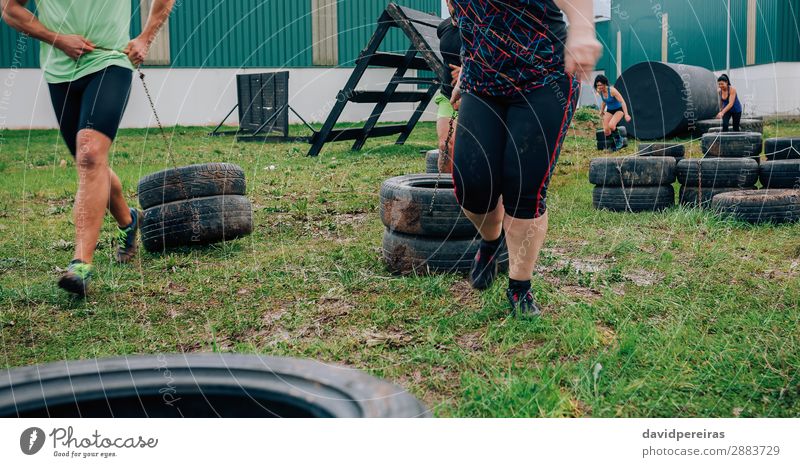 Group in obstacle course dragging wheels Joy Sports Human being Woman Adults Man Grass Smiling Authentic Strong Power Effort obstacle course race Unrecognizable