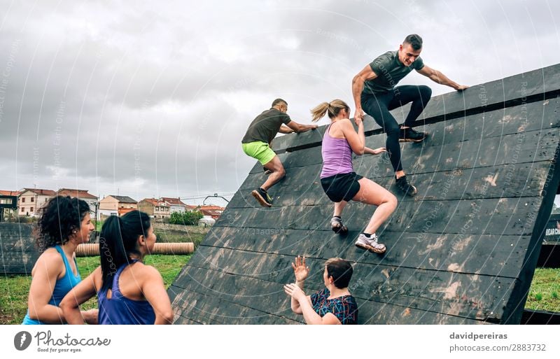 Group in obstacle course climbing pyramid Sports Climbing Mountaineering Human being Woman Adults Man Observe Authentic Strong Black Effort Competition Teamwork