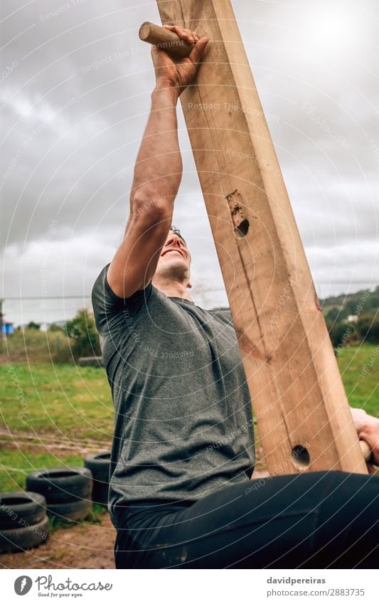 Man in obstacle course doing pegboard Lifestyle Sports Climbing Mountaineering Human being Adults Wood Authentic Strong Power Effort Competition