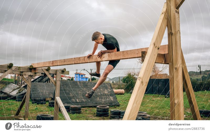 Man in obstacle course doing irish table Lifestyle Sports Human being Adults Wood Authentic Strong Power Effort Competition obstacle course race overcoming Hold