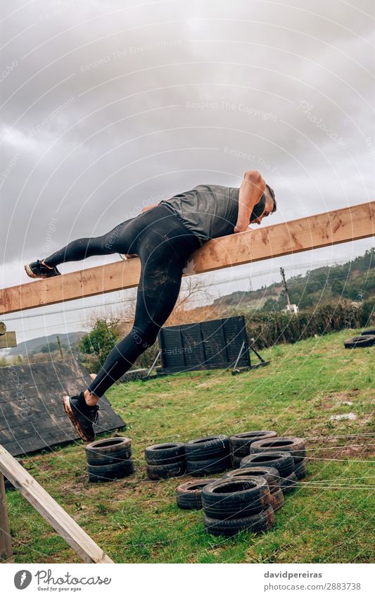 Man in obstacle course doing irish table Lifestyle Sports Human being Adults Wood Authentic Strong Power Effort Competition obstacle course race overcoming