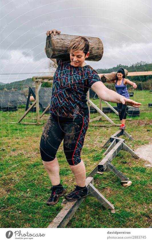 Female participants in obstacle course carrying trunks Contentment Sports Human being Woman Adults Man Smiling Carrying Authentic Dirty Strong Power Effort