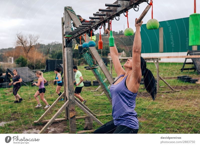 Woman in obstacle course doing suspension rings Sports Human being Adults Man Group Hang Authentic Strong Black Power Effort Competition obstacle course race