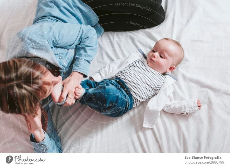 happy young mother and her baby boy lying on bed and smiling Lifestyle Joy Happy Skin Lamp Bedroom Child Human being Feminine Baby Toddler Boy (child)