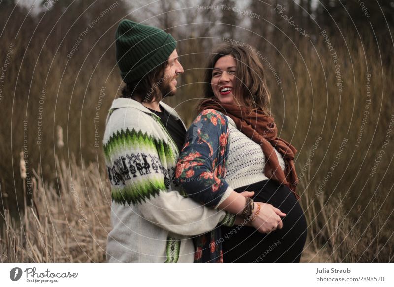 couple rejoices over upcoming birth Partner Life 2 Human being 30 - 45 years Adults Nature Spring Winter Grass Bushes Scarf Cap Brunette Long-haired Beard