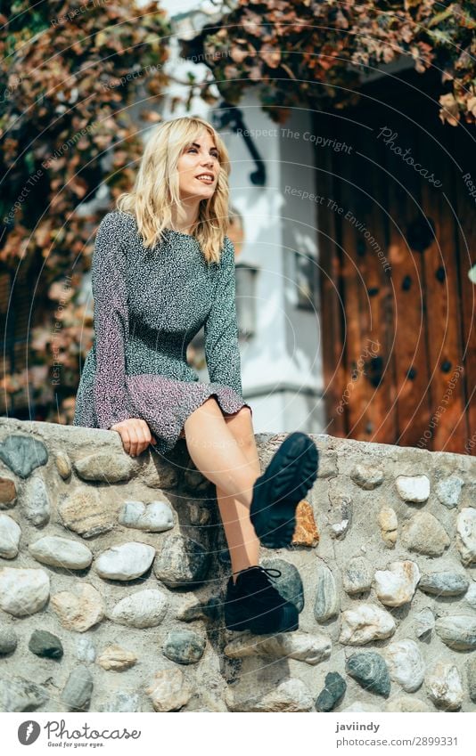 Happy young blond woman sitting on urban autumn background. Lifestyle Style Beautiful Hair and hairstyles Human being Feminine Young woman Youth (Young adults)
