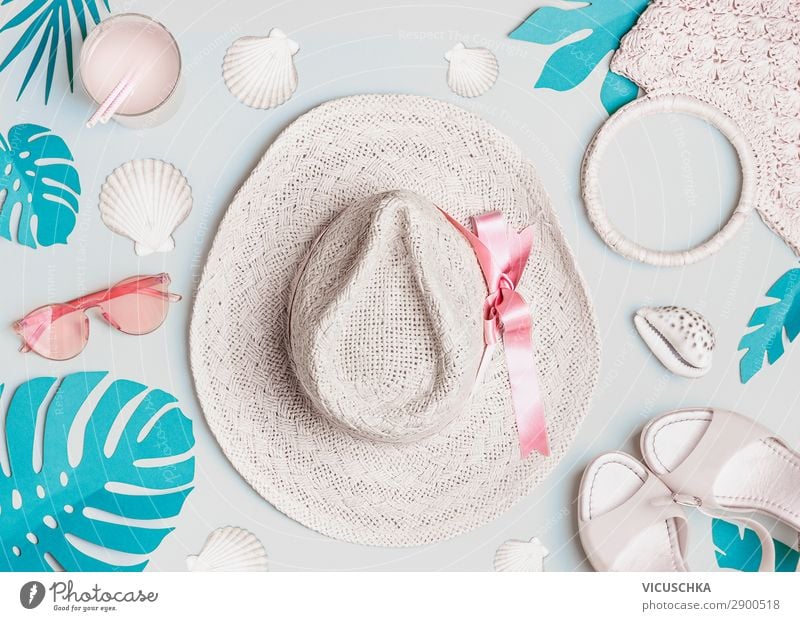 Summer woman accessories with shells and tropical leaves on pastel color background, top view. Straw hat, sunglasses, sandals and handbag. Holiday vacation. Female fashion outfit