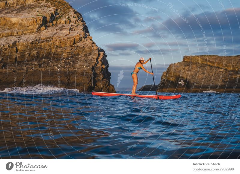 Woman on paddleboard floating in sea - a Royalty Free Stock Photo from ...