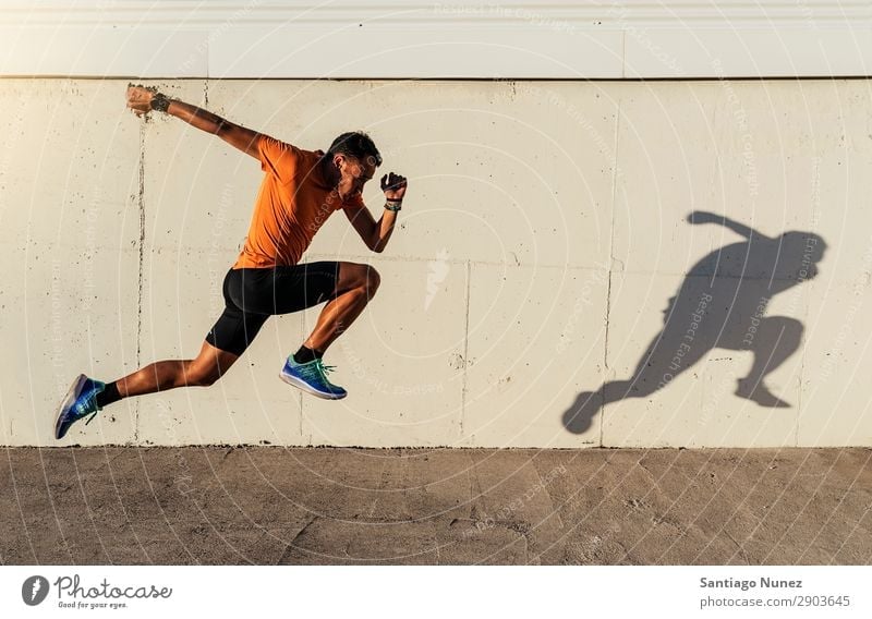 Handsome man running in the city. Man Running Jogging Runner Street City Athlete Speed Fitness Lifestyle Youth (Young adults) Town Action Shadow Healthy Sports