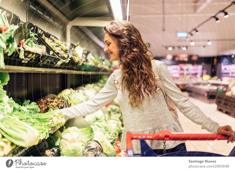 Beautiful woman taking a lettuce in supermarket. Woman Shopping Youth (Young adults) Supermarket Food Markets using Human being Smiling Cart pretty Lifestyle