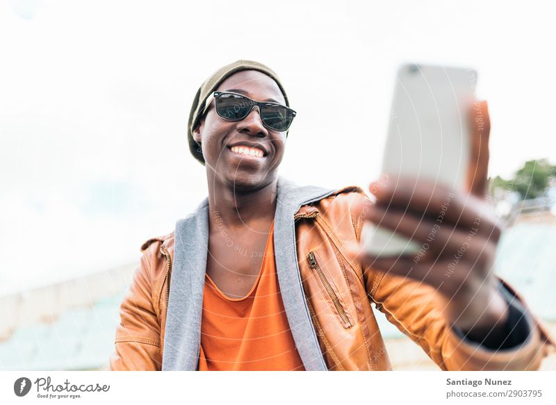 American man using mobile in the street. Man Telephone Cellphone Town African Black Mobile Youth (Young adults) Laughter PDA Technology Human being Happy