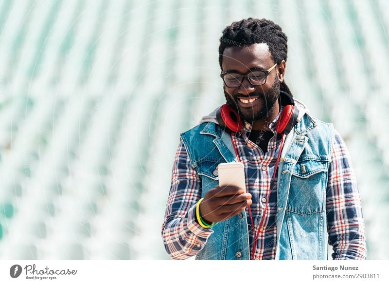 American man using mobile. Man Telephone Cellphone Town African Black Mobile Youth (Young adults) Laughter PDA Technology Human being Happy Happiness Smiling