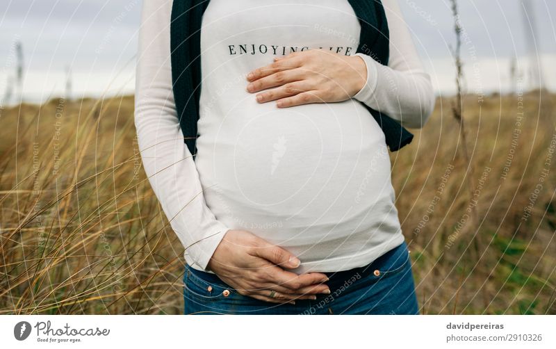 Pregnant woman caressing her tummy Lifestyle Joy Happy Leisure and hobbies Human being Baby Woman Adults Mother Family & Relations Hand Nature Landscape Grass