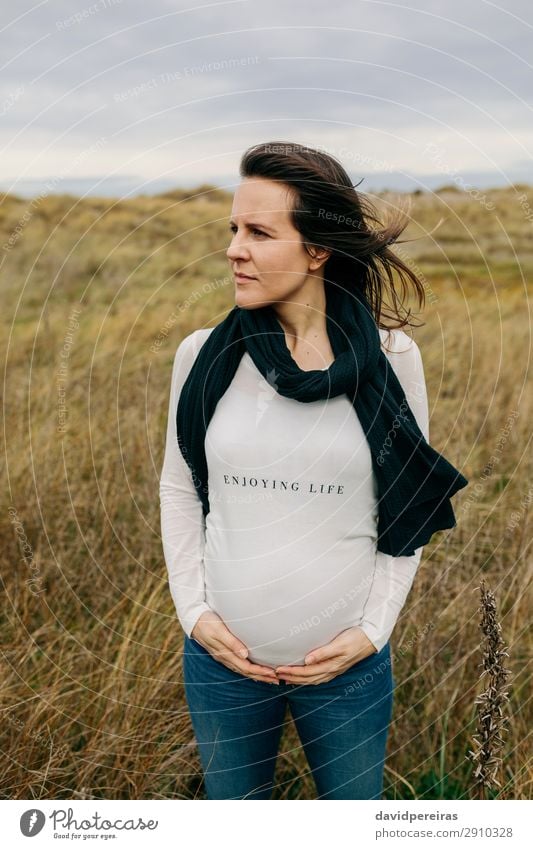 Pregnant woman caressing her tummy Lifestyle Joy Happy Human being Baby Woman Adults Mother Hand Nature Landscape Grass Meadow Scarf Touch Smiling Wait